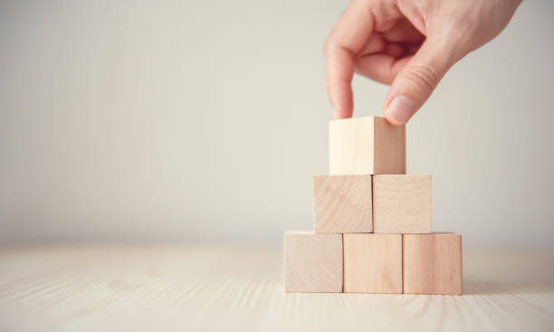 istock Hand flips blank wood cube block on top pyramid, for create icon symbol to success concept. 1161993636