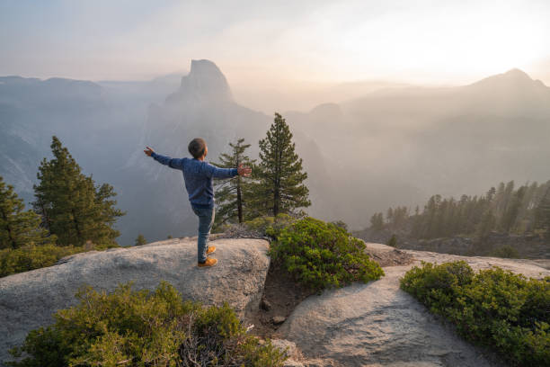 joven que acicala los brazos extendidos en la cima del valle de yosemite, ee.uu. al amanecer - condado de mariposa fotografías e imágenes de stock