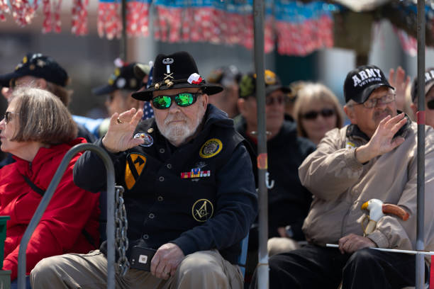 Blossomtime Festival Grand Floral Parade Benton Harbor, Michigan, USA - May 4, 2019: Blossomtime Festival Grand Floral Parade, Trailer transporting United States military veterans down the road during the parade saint joseph stock pictures, royalty-free photos & images