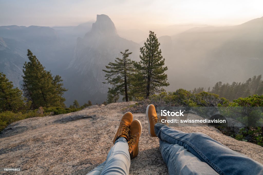 Personal perspective of couple relaxing on top of Yosemite valley; feet view Personal perspective of couple relaxing on top of Yosemite valley; feet view; 
People travel vacations relaxation concept Point of View Stock Photo