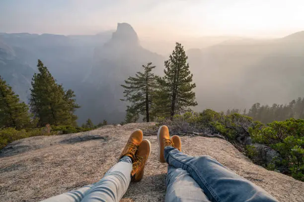 Photo of Personal perspective of couple relaxing on top of Yosemite valley; feet view