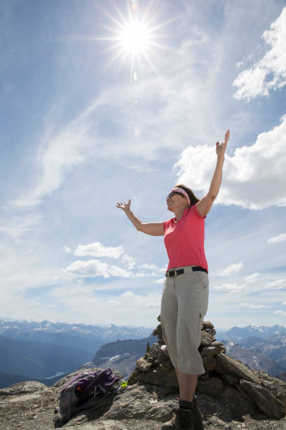 istock Senior woman celebrates on summit of mountain 1161997724