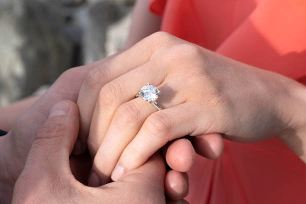 istock A man holding a woman's hand to showoff her diamond ring 1161997880