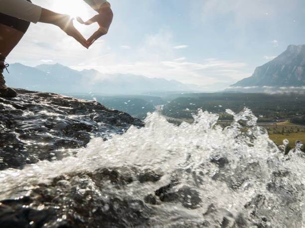 istock Hands forming the heart symbol above a mountain stream 1161997934