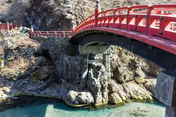 Closeup of famous red Shinkyo bridge landmark by mountains in Nikko, Tochigi prefecture in Japan in early spring with Daiya river