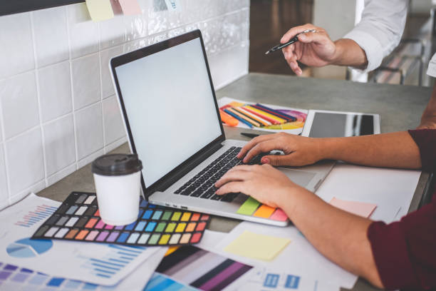 istock Teamwork of creative designers working on new project and choose color swatch samples for selection coloring on digital graphic tablet with work tools and equipment at workplace 1162005012