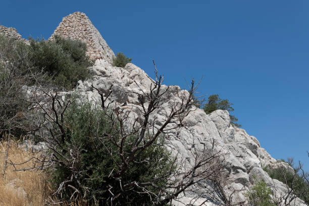 The ruins of the long abandoned medieval Apolichnon fortification situated northwest of the Armolia village on top of a 220 metres tall mountain on a sunny hot day in summer.