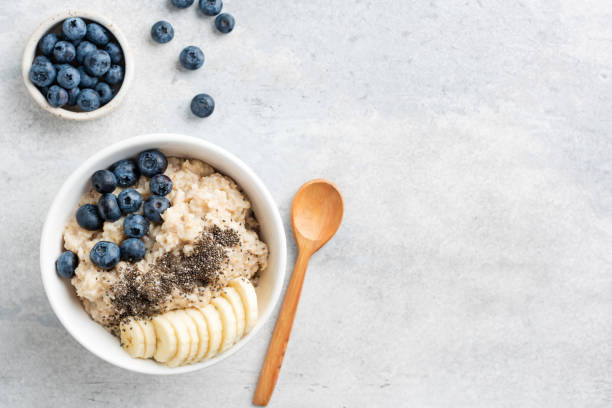 healthy breakfast oatmeal bowl with banana, blueberry - chia seed spoon food imagens e fotografias de stock