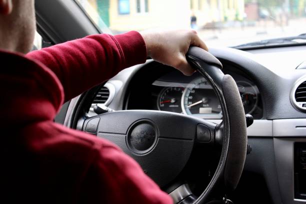 istock Rear view of man driving car 1162020549
