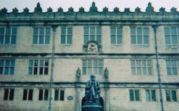 Photograph of the outside of Shrewsbury Library, Shropshire, United Kingdom, with statue of local son, Charles Darwin.
