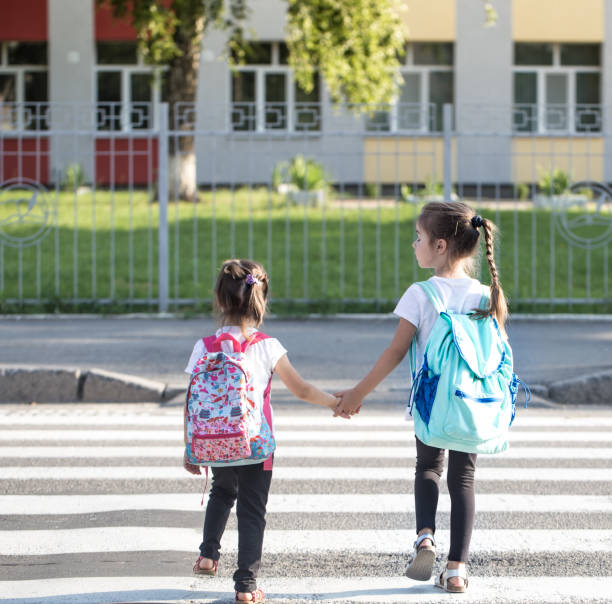 istock Back to school education concept with girl kids, elementary students, carrying backpacks going to class 1162024533