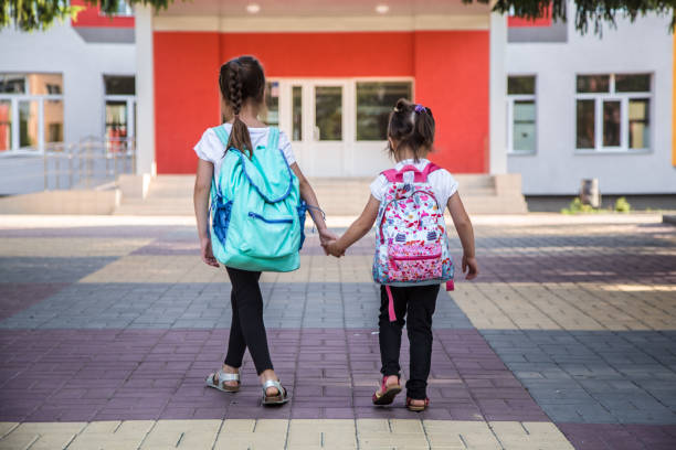 istock Back to school education concept with girl kids, elementary students, carrying backpacks going to class 1162024547