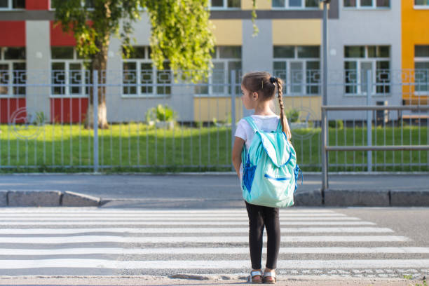 istock Back to school education concept with girl kids, elementary students, carrying backpacks going to class 1162024651