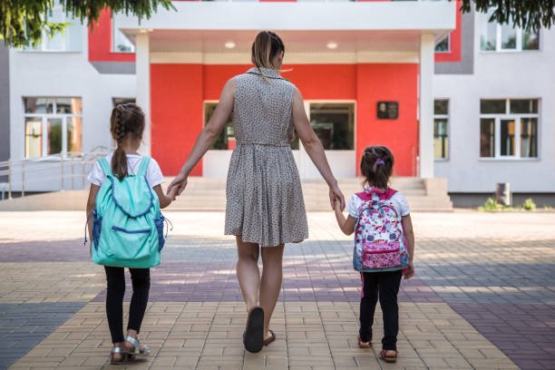 istock Back to school education concept with girl kids, elementary students, carrying backpacks going to class 1162024936