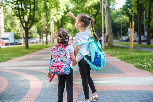 istock Back to school education concept with girl kids, elementary students, carrying backpacks going to class 1162025045