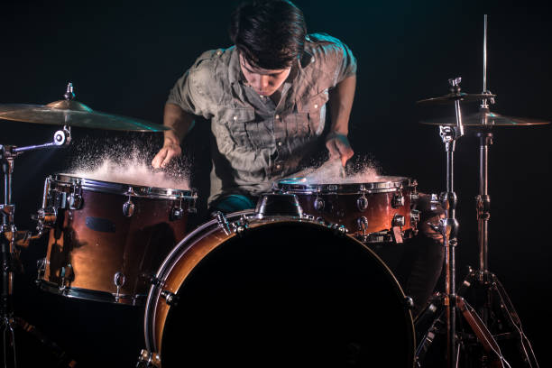 musician playing drums with splashes, black background with beautiful soft light musician playing drums with splashes, black background with beautiful soft light, emotional play, music concept drummer hands stock pictures, royalty-free photos & images