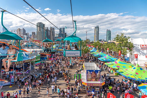 Calgary, Alberta - July 13, 2019: Ariel view of the Calgary Stampede grounds taken from a chairlift attraction on the Stampede grounds. The Calgary Stampede is one of the largest agricultural, rodeo and midways in the world. There are many festival goers visible on the ground.