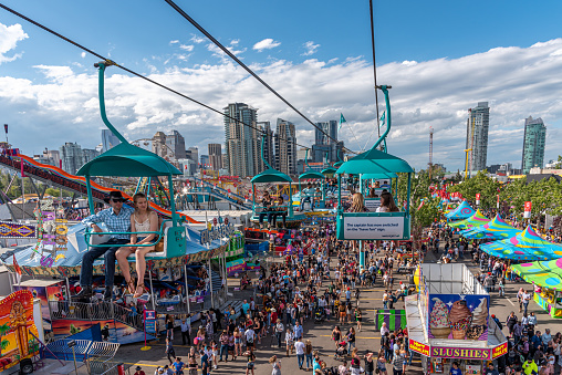 Calgary, Alberta - July 13, 2019: Ariel view of the Calgary Stampede grounds taken from a chairlift attraction on the Stampede grounds. The Calgary Stampede is one of the largest agricultural, rodeo and midways in the world. There are many festival goers visible on the ground.