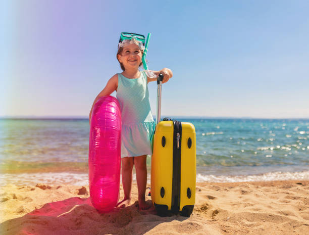 istock Girl holding and inflatable ring and suitcase 1162029575