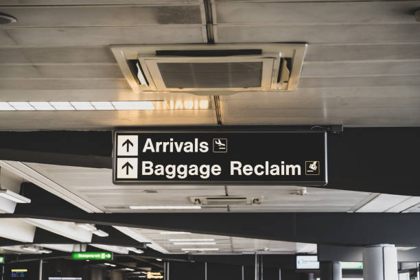 Arrivals and baggage reclaim directional signs in an airport Arrivals and baggage reclaim directional signs within the public concourse of London Stansted Airport, Essex, England. emergency exit photos stock pictures, royalty-free photos & images