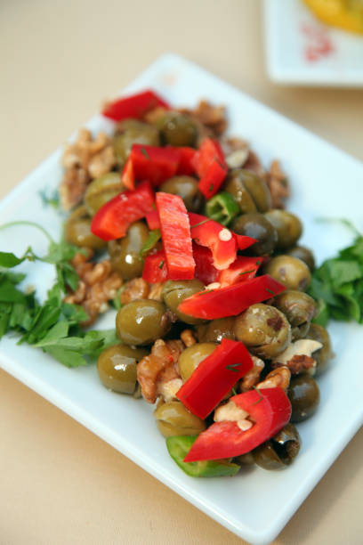 Traditional Turkish appetizer food 'Green olives and walnuts' on the restaurant table.