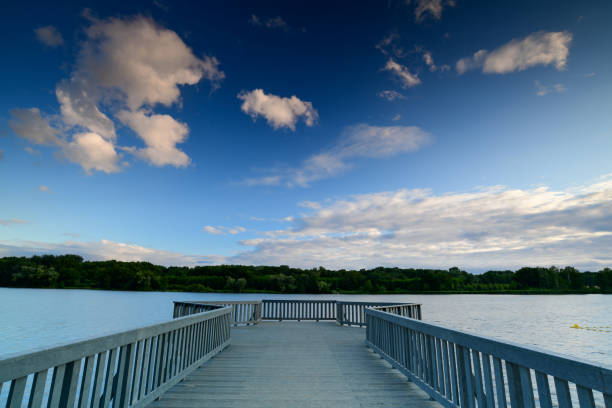 istock empty wooden pier and beautiful lake with forest on horizon 1162031333