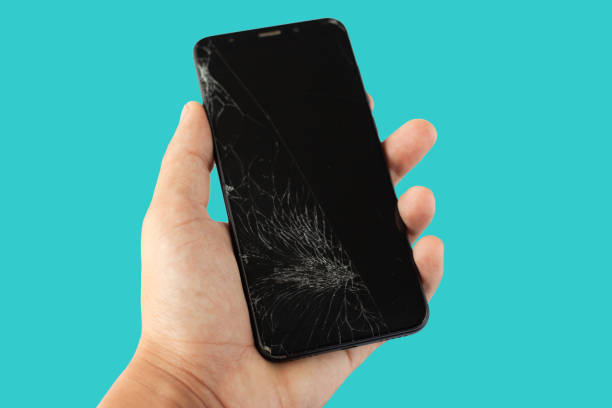istock black broken phone in hand on aquamarine  background cracked touchscreen screen 1162036508