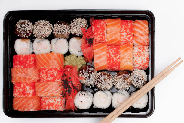 istock Big sushi set ib black plastic box on white background, top view close up, copy space 1162036802