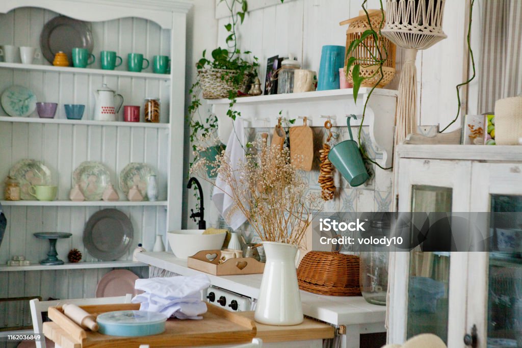 Stylish and sunny interior of kitchen space with small wooden table at the photo studio. Scandinavian room decor with kitchen accessories. Stylish and sunny interior of kitchen space with small wooden table at the photo studio. Scandinavian room decor with kitchen accessories Abstract Stock Photo