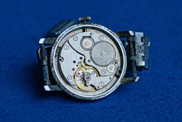 istock old gray clock with an open mechanism lies on a blue table 1162043291