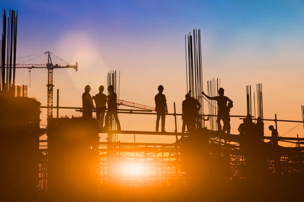 Silhouette of engineer and construction team working at site over blurred background for industry background with Light fair.Create from multiple reference images together