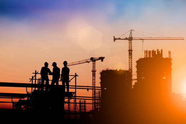 Silhouette of engineer and construction team working at site over blurred background for industry background with Light fair.Create from multiple reference images together Silhouette of engineer and construction team working at site over blurred background for industry background with Light fair.Create from multiple reference images together construction equipment photos stock pictures, royalty-free photos & images