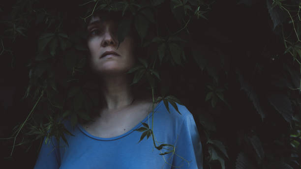 istock Girl looking forward on dark nature background 1162048255