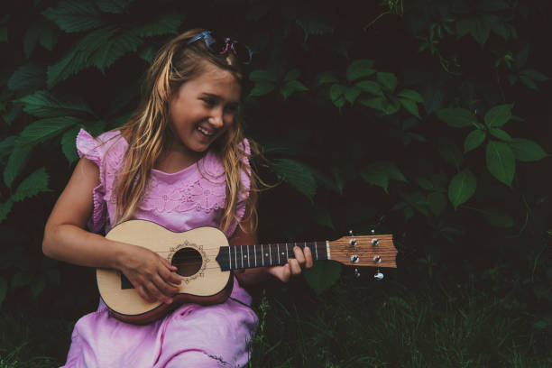 belle jeune fille avec le ukulélé - musical instrument nature outdoors musician photos et images de collection