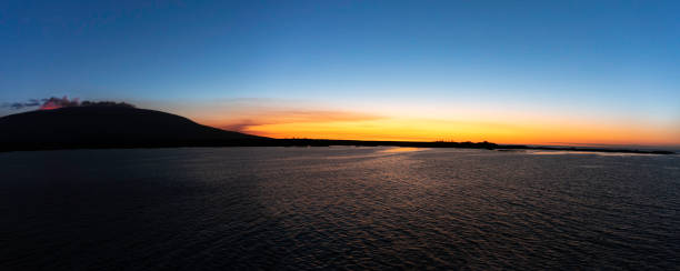 Fernandina Island in the Galapagos Islands with a volcano erupting at sunset