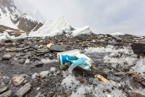 Garbage scattered over snowy mountain. Let's save the planet and recycle the excess garbage.