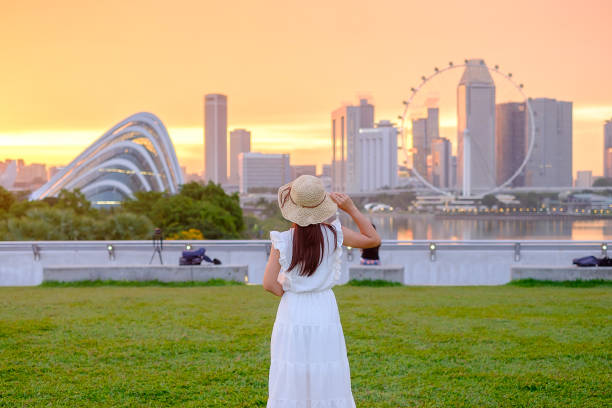 선셋에서 모자를 쓰고 여행하는 젊은 여성, 싱가포르 시내에서 행복한 아시아 여행자 방문. 랜드 마크와 관광 명소에 대 한 인기. 아시아 여행 컨셉 - pleasant bay 뉴스 사진 이미지