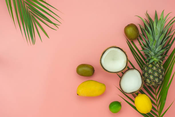 istock Table top view fruit tropical with spring summer holiday & vacation  background concept.Arrangement sliced various pineapple mango lemon and lime on palm green leaves.Items on pink paper.pastel. 1162056194