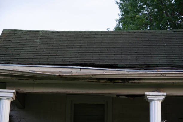 istock Damaged and old roofing shingles and gutter system on a house 1162064327
