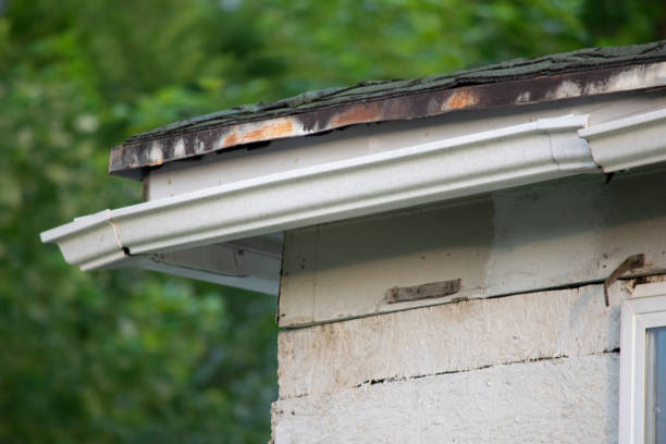 istock Damaged and old roofing shingles and gutter system on a house 1162064350