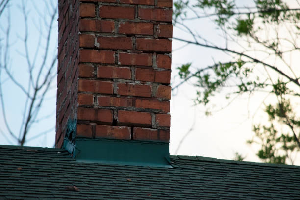 istock Damaged and old roofing shingles and chimney on a house 1162064509