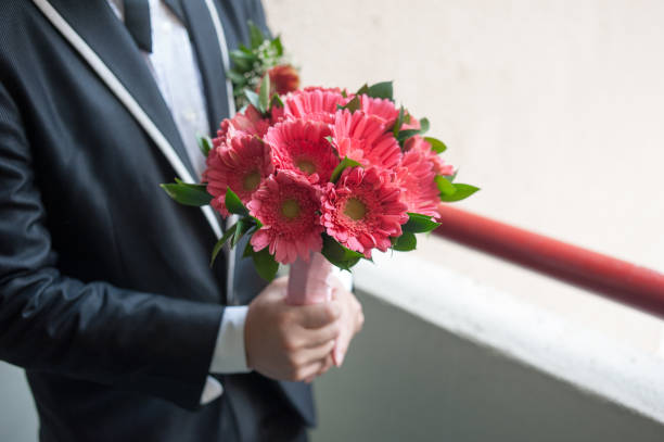 Image of Groom holding beautiful wedding flowers bouquet.