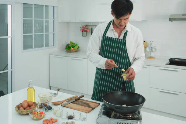 istock Attractive asian young man cooking food in the nice kitchen for dinner 1162067359