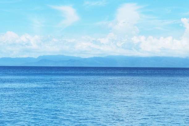 istock Beautiful white clouds on blue sky over calm sea with sunlight reflection, Sunny sky and calm blue ocean at Nyaung Oo Phee Island , Myanmar. 1162068915