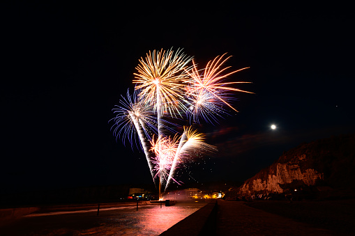 This photo was taken in France, north of Normandy, in Saint-Valery-en-Caux during the festivities of July 14. We see the port illuminated by the lights of fireworks.