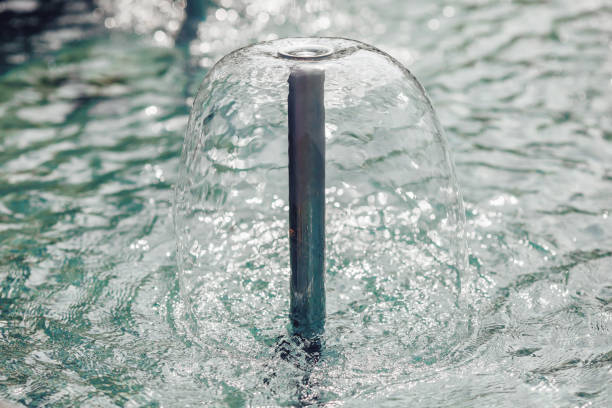 istock Fountain with copper pipes, blue water and jets 1162072901