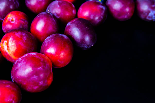Fruits of garden plums on a black background.