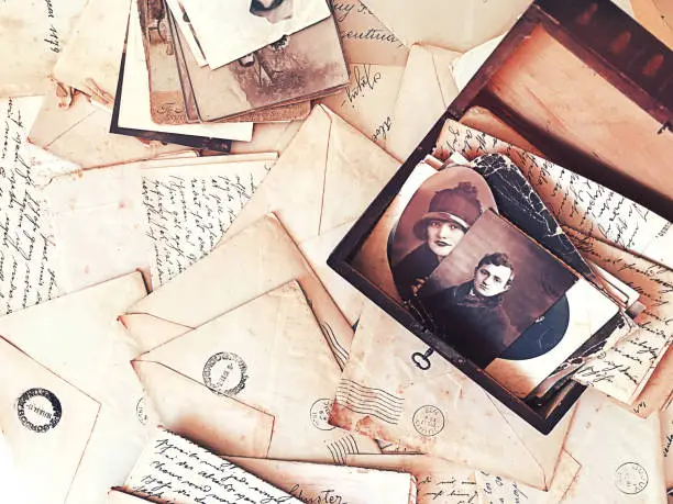 Scattered vintage letters and photos with a wooden box with old photos and more letters