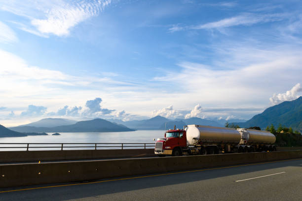 Double trailer fuel tanker driving along a scenic coastal highway. Transport truck driving along highway 99 or the Sea to Sky highway.