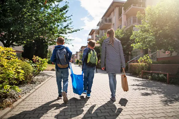 Photo of Three kids carrying shopping home in resusable shopping bags